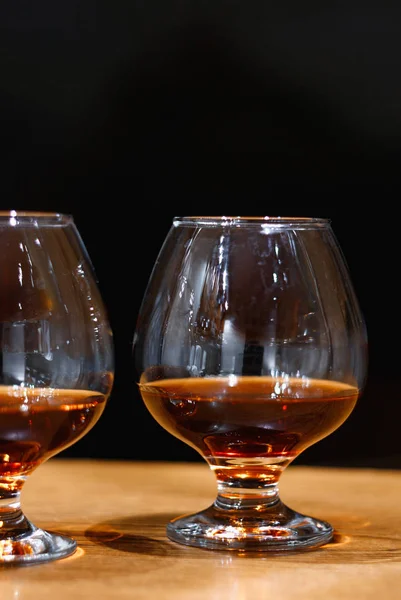 Two goblets of brandy on wooden old counter top — Stock Photo, Image