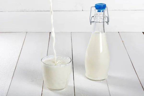 Old  vintage style bottles with fresh milk on  white wooden table — Stock Photo, Image