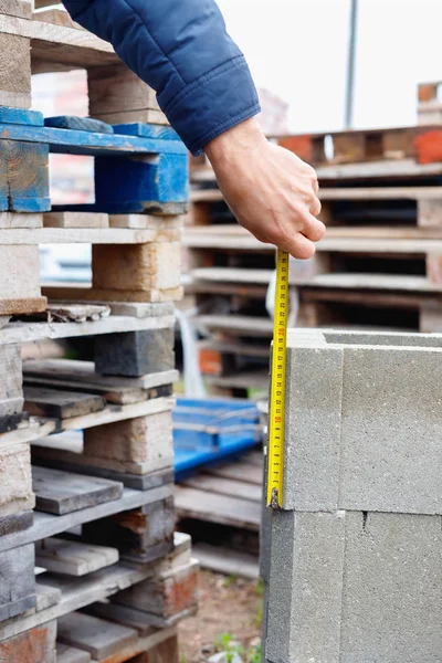 Trabajador mide bloques de cemento en el almacén — Foto de Stock