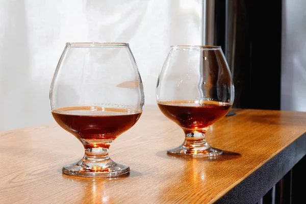 Dva pohárů brandy na starý dřevěný pult — Stock fotografie