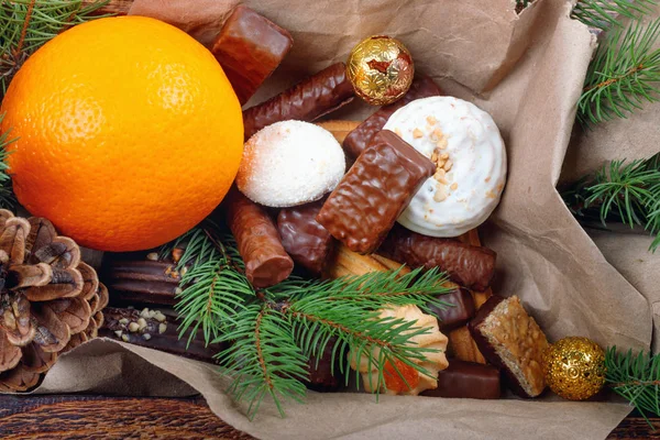 Deliciosos dulces, chocolates, galletas y naranjas para regalos en caja de madera — Foto de Stock
