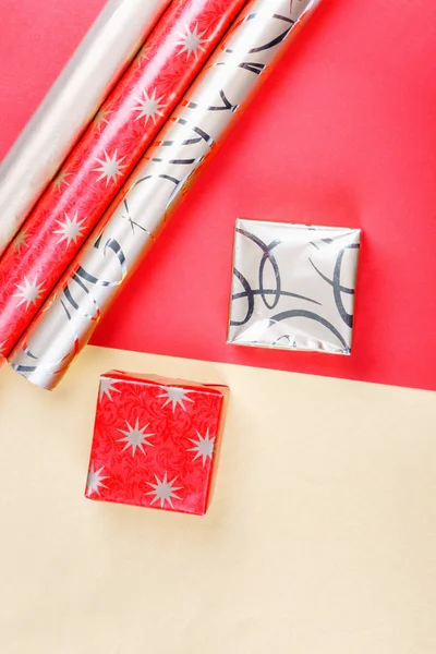 Goldene Geschenkboxen und rotes Geschenkpapier auf hellem Hintergrund — Stockfoto