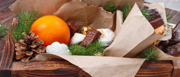Läckra sötsaker, choklad, kakor och apelsiner för gåvor i — Stockfoto