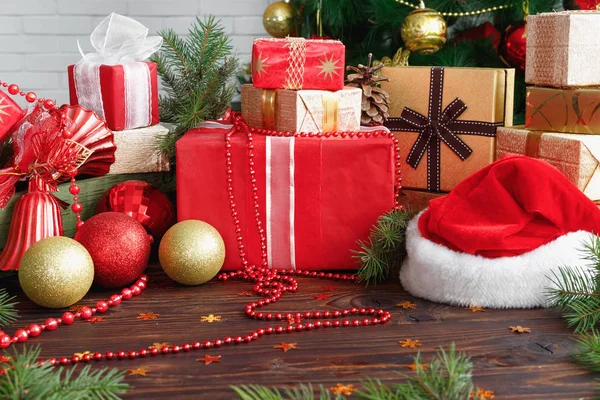 Cajas de regalo con cuentas, juguetes y sombrero de Santa Claus en mesa de madera vintage —  Fotos de Stock