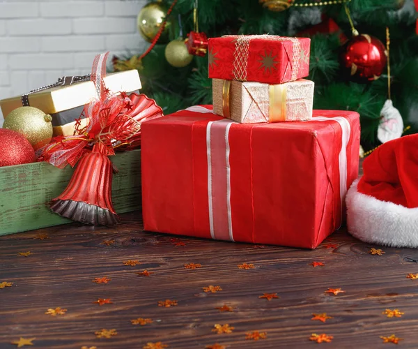 Presentaskar med pärlor, leksaker och jultomte hatt på vin Tage träbord — Stockfoto