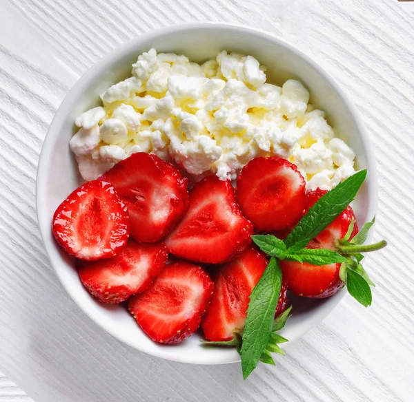 White bowl with fresh red ripe strawberries and natural cottage cheese — Stock Photo, Image