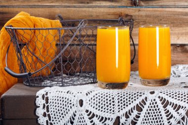 Eski ahşap duvarda taze kabak ve portakal suyu 