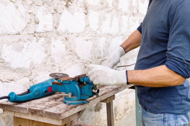 İşçi arka bahçede elektrikli aletler çekiç ve penye ile onarım yapar 