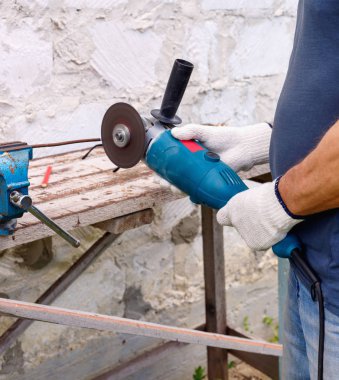 İşçi arka bahçede elektrikli aletler çekiç ve penye ile onarım yapar 