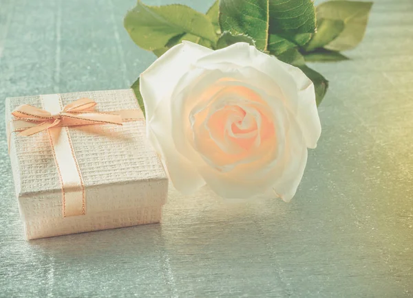 Vacker vit ros med en gyllene presentförpackning för alla hjärtans dag — Stockfoto