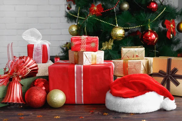 Caixas de presente com contas, brinquedos e chapéu de Papai Noel na mesa de madeira vintage — Fotografia de Stock