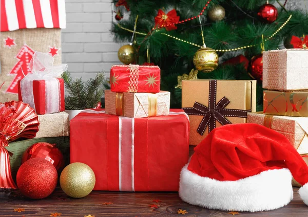 Cajas de regalo con cuentas, juguetes y sombrero de Santa Claus en mesa de madera vintage —  Fotos de Stock