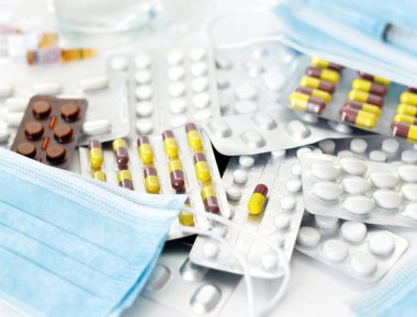 Coronavirus ilaçları ve beyaz arka plandaki personel için koruyucu tıbbi maskeler. Coronavirus aşısı. Boşluk konseptini kopyala.