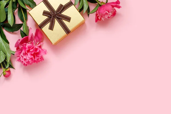 金光闪闪的节日礼盒 上有蝴蝶结和粉红色背景的美丽牡丹花束 带空位的度假概念 — 图库照片