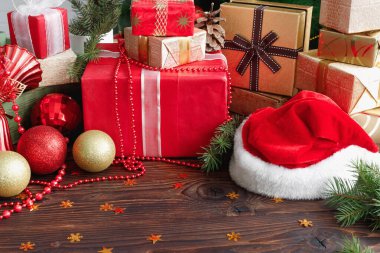 Noel 'de içinde boncuklar, oyuncaklar ve Noel Baba şapkası olan hediye kutuları.