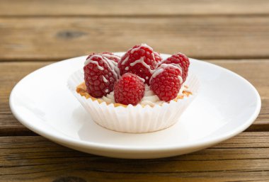 Beyaz tabakta küçük ahududu keki.