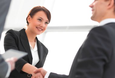 İş kadını toplantı sırasında bir işadamıyla tokalaşıyor.