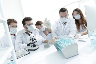 tıp doktorları laboratuarda test tüpleri ve mikroskop ile çalışıyoruz