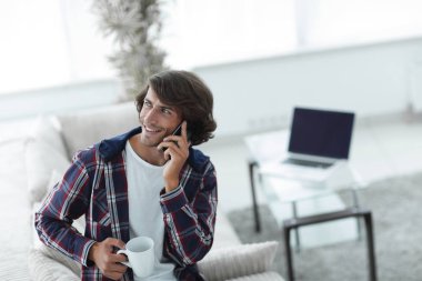 güzel bir fincan adamla bir dizüstü bilgisayar önünde oturur.