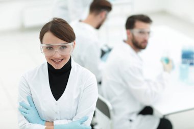 Laboratuvar arka planda bilim adamı portresi.