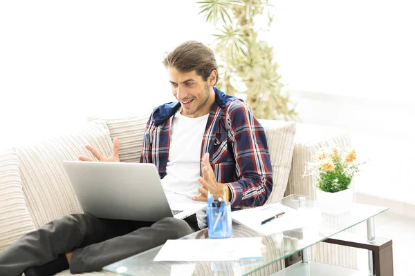 Joven feliz trabajando con el ordenador portátil desde casa . — Foto de Stock