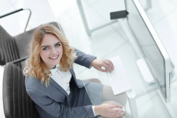 Leende affärskvinna som sitter bakom ett skrivbord — Stockfoto