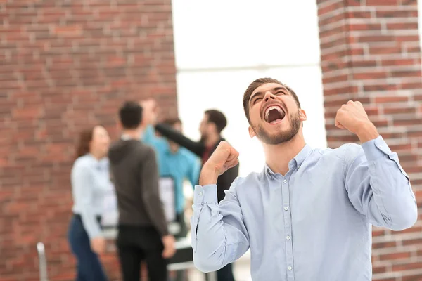 Hombre de negocios guapo celebrando la victoria gritando felizmente en th — Foto de Stock