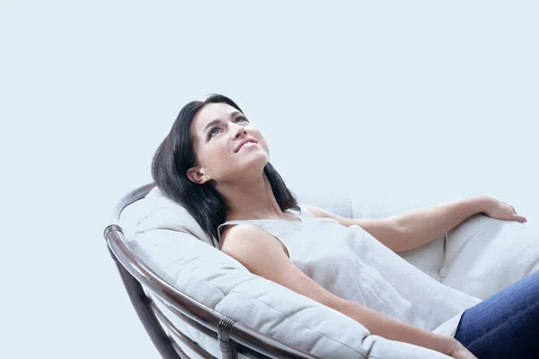 Schöne junge Frau entspannt in einem runden gemütlichen weichen Stuhl. — Stockfoto