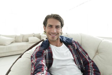 bir sandalyede oturuyor ve elini tutarak kendine güvenen adam.