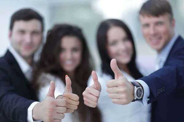 Triumphant business team holding thumbs up — Stock Photo, Image