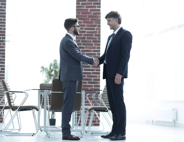 Dwóch biznesmenów uścisnąć dłoń w biurze — Zdjęcie stockowe