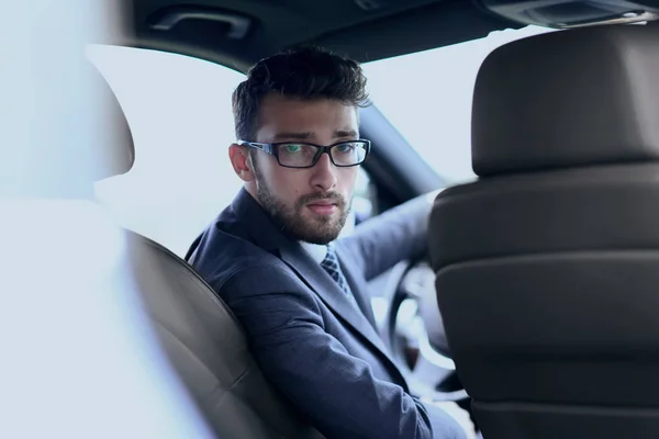 Man in formalwear sitting in car — Stock Photo, Image