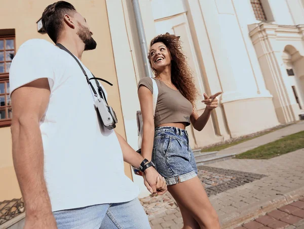 Bir çift şehrin sokaklarında yürüyor ve eğleniyor.