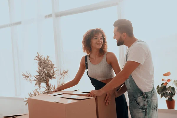 Recién casados llevan cajas en un nuevo apartamento . — Foto de Stock