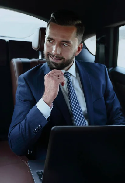 Úspěšný muž, sedící na zadním sedadle auta — Stock fotografie