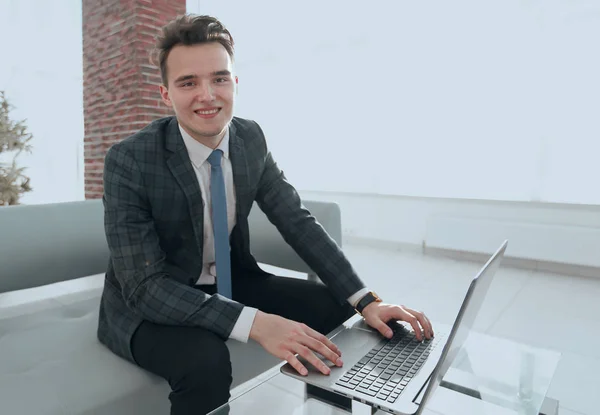 Jeune homme d'affaires travaillant avec un ordinateur portable au bureau — Photo