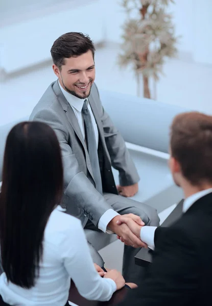 Handskakning affärspartner i lobbyn på kontoret. — Stockfoto