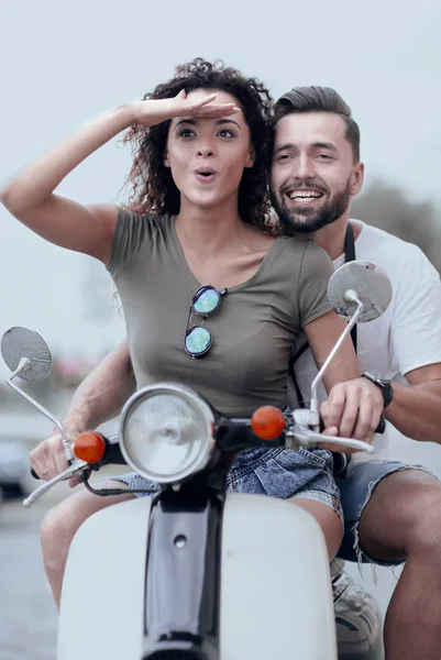 Красива молода пара посміхається під час їзди на скутері — стокове фото
