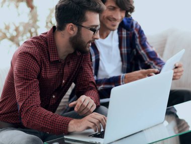 İki web tasarımcıları bir proje bir dizüstü bilgisayar önünde tartışmaya portresi