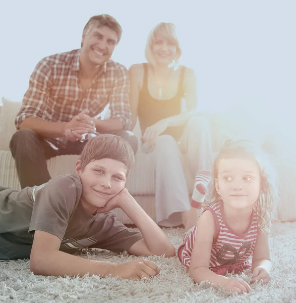 Portret van kinderen terwijl de ouders zitten op de Bank in levende roo — Stockfoto