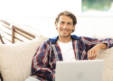 dizüstü bilgisayarda çalışan ve kameraya bakarak başarılı adam. Yukarıdan görüntülemek