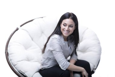 Genç kadın bir yuvarlak rahat yumuşak büyük sandalyede oturuyor.