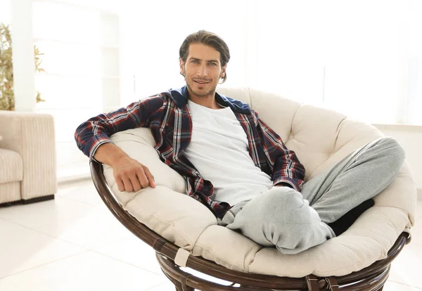 Chico exitoso descansando en la sala de estar moderna . — Foto de Stock