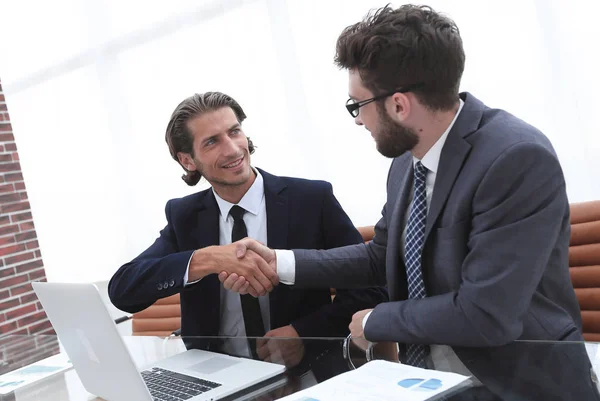 Handshake homem de negócios sentado atrás de uma mesa . — Fotografia de Stock