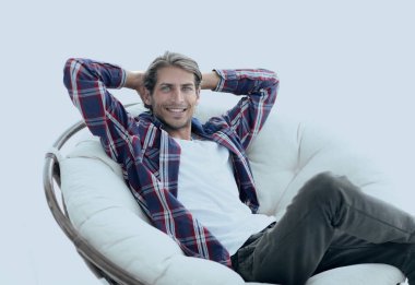 yakın çekim. başarılı bir adam büyük bir yuvarlak rahat sandalyede oturuyor