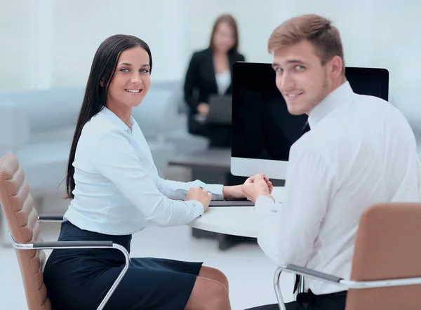 Medlemmar i affärsteamet sitter vid skrivbordet och tittar på kameran . — Stockfoto