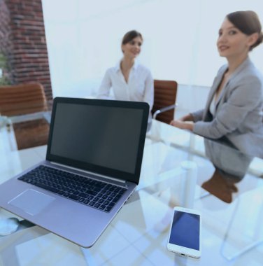 Bir iş adamının bilgisayarında bilgisayar ve akıllı telefon.