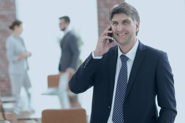 Kendine güvenen iş adamı telefonda konuşuyor..