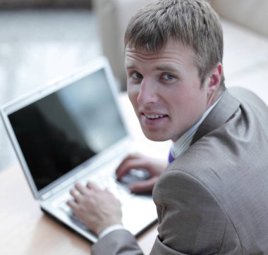 Bir dizüstü bilgisayarda çalışan takım elbiseli genç adam Üstten Görünüm