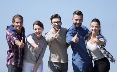 başparmak gösterilmesini gençlerin grup gülümseyen.